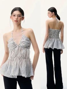 Woman in a striped halter top and black pants posing in a studio