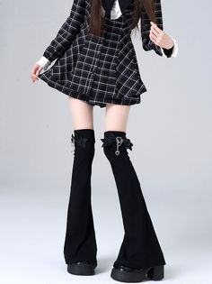 Person in a plaid dress with black leg warmers and platform shoes