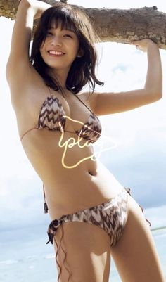 Woman in a patterned bikini smiling and posing outdoors