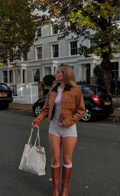 Woman in a brown jacket and short shorts on a street