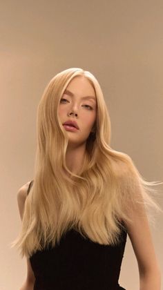 Woman with long blonde hair wearing a black top, looking at the camera