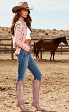 Woman in a cowboy hat and pink studded jacket with a horse in the background