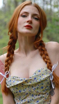 Woman with red braided hair and a floral top outdoors