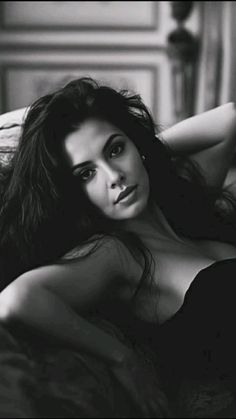 Woman with long dark hair in a provocative pose, black and white photograph