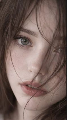Close up portrait of a woman with brown messy hair and green eyes