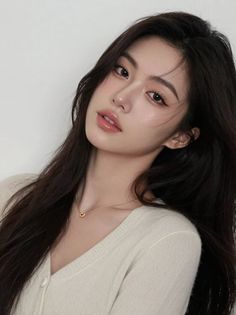 Woman with long black hair wearing a v-neck top and gold necklace