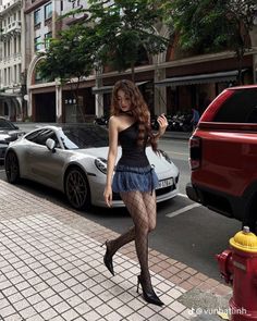 Woman in a mini skirt and fishnet stockings walking on a city street