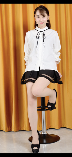 Woman in a white blouse and black skirt posing on a bar stool