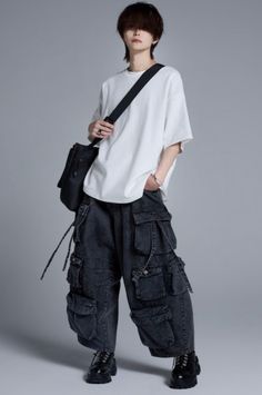 Person in a white t-shirt and baggy cargo pants with a black shoulder bag