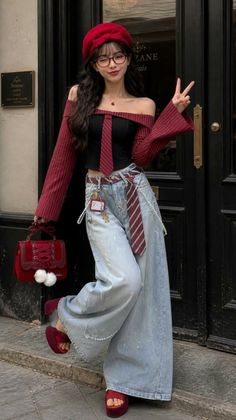 Woman in a red beret and off-shoulder top with wide-leg jeans posing outdoors
