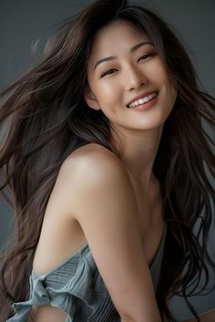 Smiling woman with long wavy hair and exposed shoulders