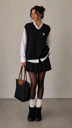 Woman in a black sweater vest, white shirt, and pleated skirt holding a tote bag