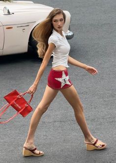 Woman in a red mini skirt and white shirt walking outdoors