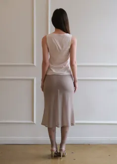 Woman with long hair wearing a sheer skirt and high heels, seen from behind