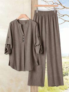 Brown long sleeve shirt and wide leg pants hanging against an outdoor background