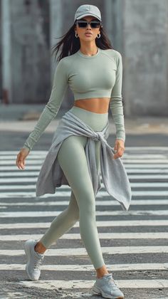 Woman in athletic wear and sunglasses walking on a zebra crossing