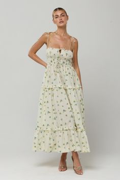 Woman in a white floral print maxi dress with ruffles and an updo