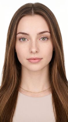 Young woman with long brown hair and green eyes wearing a gold chain