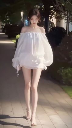 Woman in an off-shoulder top and high heels walking outdoors at night