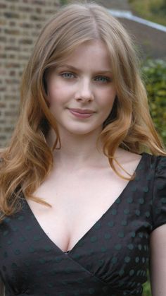 Woman with long blonde hair and blue eyes in a polka dot dress outdoors