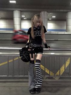 Person in alternative fashion with pigtails and striped leg warmers in an underpass