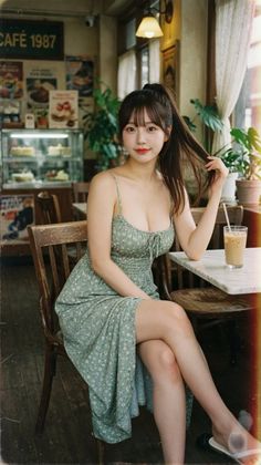 Woman in a floral dress sitting in a cafe with an iced coffee