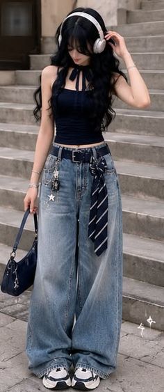 Woman with long black hair wearing headphones, a crop top, and wide leg jeans