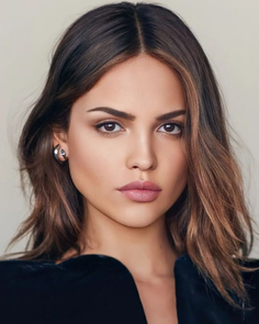 Woman with long brown hair and earrings in a portrait shot