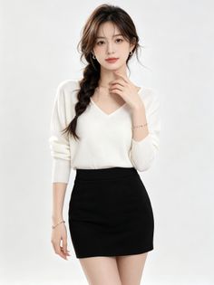 Woman with braided long hair wearing a white sweater and black skirt