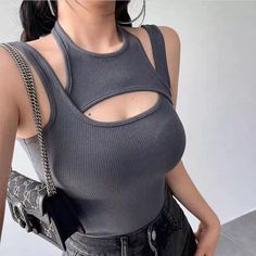 Woman wearing a gray ribbed top with a chest cut-out and dark wash jeans