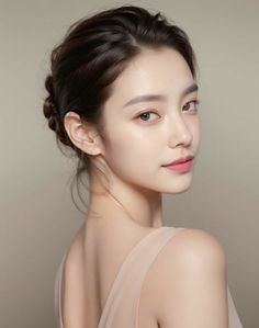 Woman with an updo hairstyle and bare shoulders in a studio portrait