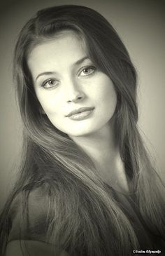 Woman with long hair in a sepia-toned portrait with soft lighting
