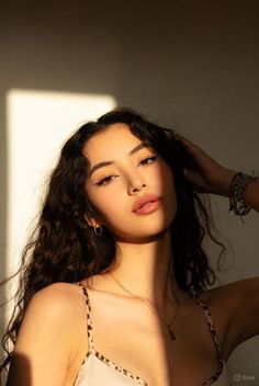 Woman with long wavy hair in a leopard print top with dramatic lighting