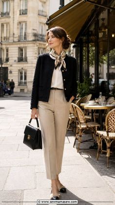 Woman in a black jacket and beige pants with a silk scarf on a street