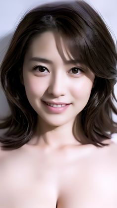 Smiling woman with dark hair and exposed shoulders, soft lighting