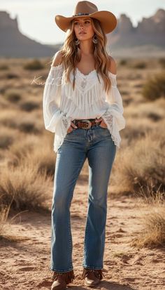 Woman in a cowboy hat and off-shoulder top standing in a desert landscape
