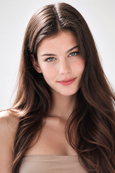 Woman with long brown hair and blue eyes in a studio portrait