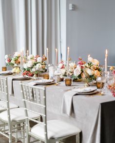 Elegant dining table set with floral arrangements and lit candles