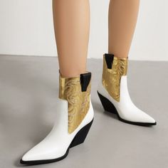 Pair of white and gold cowboy ankle boots with wedge heels