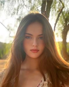 Woman with long hair and blue eyes outdoors during golden hour