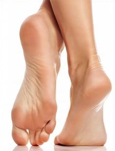 Pair of bare feet with soles visible against a white background