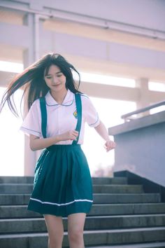 Young woman in a school uniform walking down outdoor stairs