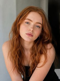Woman with red hair and blue eyes wearing a strapless top