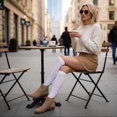 Blonde woman in a mini skirt and knee-high socks at an outdoor cafe