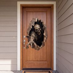 Zombie breaking through a wooden front door as a Halloween decoration