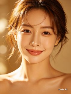 Woman with brown hair and bare shoulders smiling in soft, warm lighting
