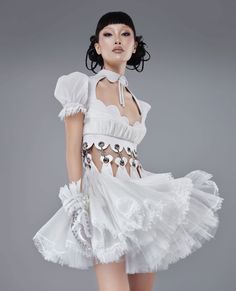 Woman in a white dress with heart cutouts and ruffled skirt
