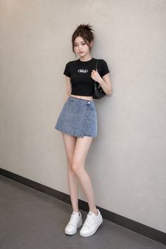 Woman in a black crop top and denim skirt with a messy bun