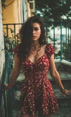 Woman in a red floral dress with curly hair outdoors