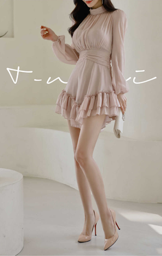 Woman in a pink ruffle dress and high heels holding a white clutch